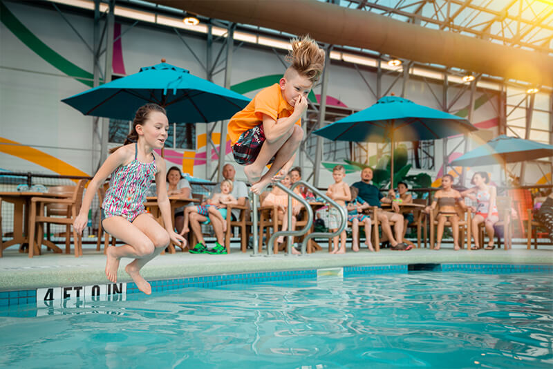 young children jumping into the water