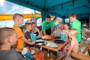 Kids enjoying pizza in cabana